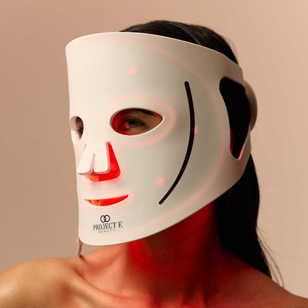 Close-up of a woman wearing the LumaLux Face LED mask with red light visible inside