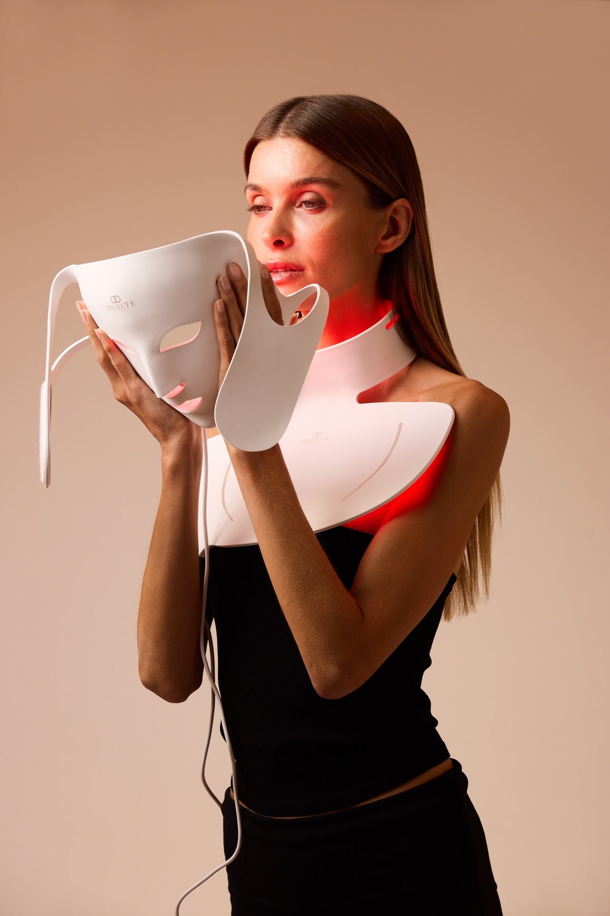 LumaLux Face+ V2 neck piece worn with the face mask in hand
