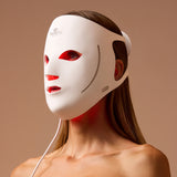 Woman wearing the white LumaLux Face V2 mask with red light glowing through the eye, nose and mouth openings